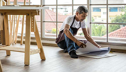 Woman working power-sanding wood