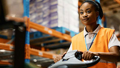 Woman working in storage area with lift machine