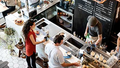 Small business owner serving his customer coffee.